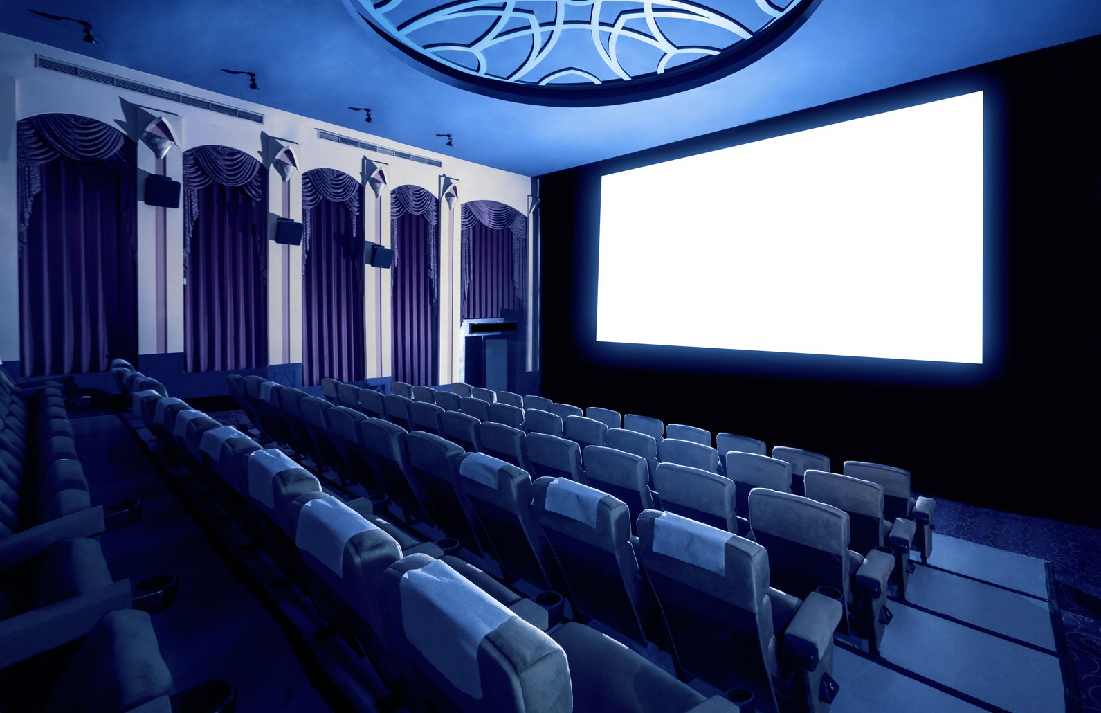 Cinema theater showing empty white movie screen.